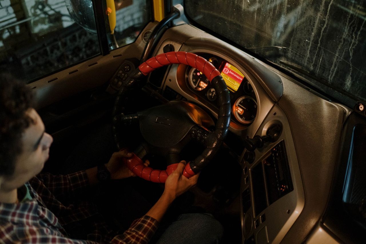 why-choose-us-02 Interior view of a car dashboard and driver focused on steering at night.